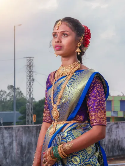 A majestic portrait against the evening sky. This shot from a puberty ceremony uses the open-air setting to create a grand and timeless feel, highlighting the elaborate hairstyle and traditional jewelry.