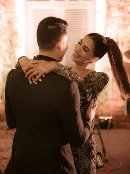 A romantic dance at the welcome dinner. The bride's sleek ponytail and glowing makeup are perfect for this chic, black-tie look.