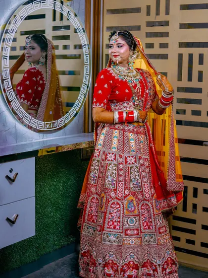 A full-length bridal portrait showing off the magnificent wedding lehenga. The reflection in the mirror adds depth, allowing us to see the bride's complete look from multiple angles.