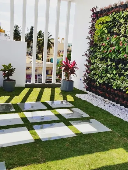 After: The same terrace is now a stunning rooftop garden, complete with a vertical garden, a neat lawn, and modern stone pavers. This is the result of our complete design and execution service.