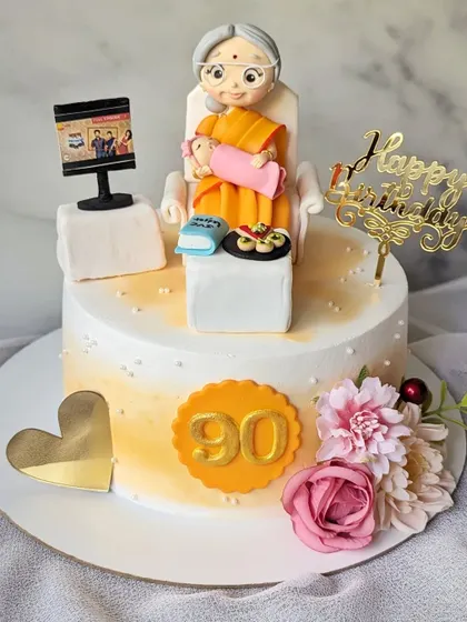A cake to celebrate a great-grandmother's 90th birthday. I included a custom figurine of her with the new baby, watching TV, and enjoying her favorite snacks, pani puri and pizza.