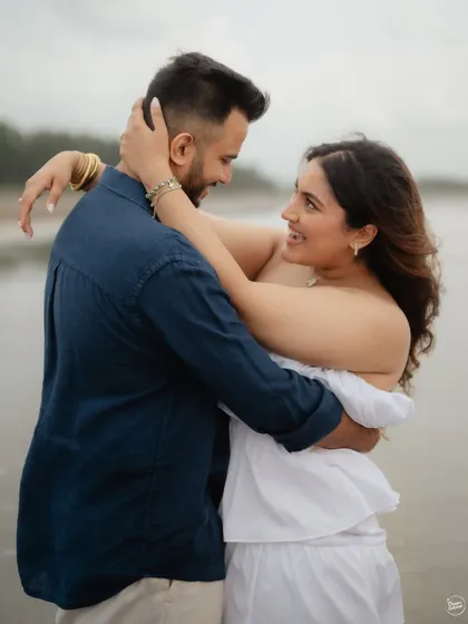 A sweet embrace by the ocean. This close-up shot focuses on the couple's happy expressions and loving interaction, creating a warm and intimate portrait from their beach pre-wedding shoot.