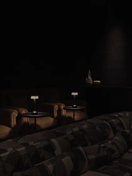 A detail of the home theatre's intimate lighting, with small table lamps providing a soft glow for a cozy movie night.