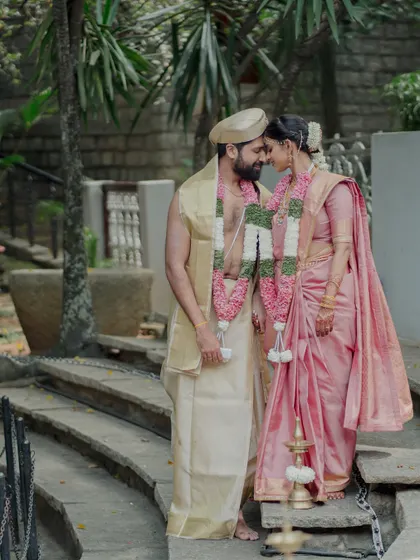 A quiet moment shared between the couple on the steps of the venue. The natural, rustic setting provides a beautiful contrast to their elegant traditional wedding attire.