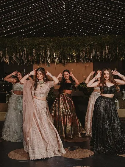 The bride and her bridesmaids in perfect sync, enjoying their moment on the sangeet stage.