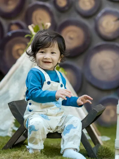 A perfect smile from this happy boy in our outdoor camping setup. The rustic log wall and teepee create a wonderful backdrop.