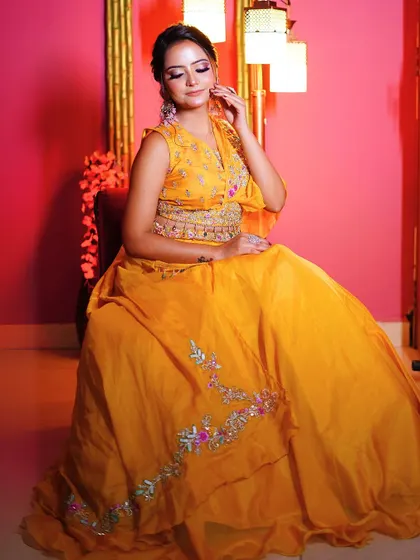 A seated portrait in the yellow Haldi lehenga, capturing a moment of elegance and grace.