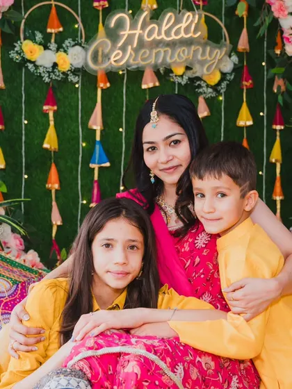 The bride sharing a sweet moment with the children in the family during her colorful Haldi ceremony.