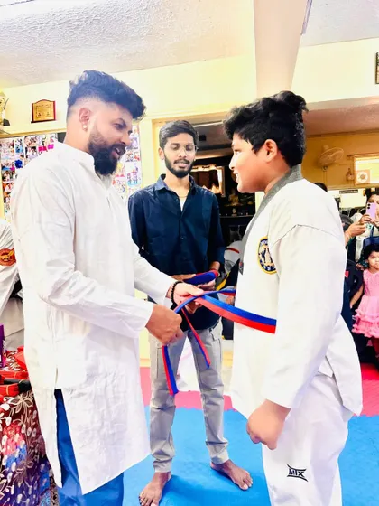 This student looks proud as he receives his new belt.