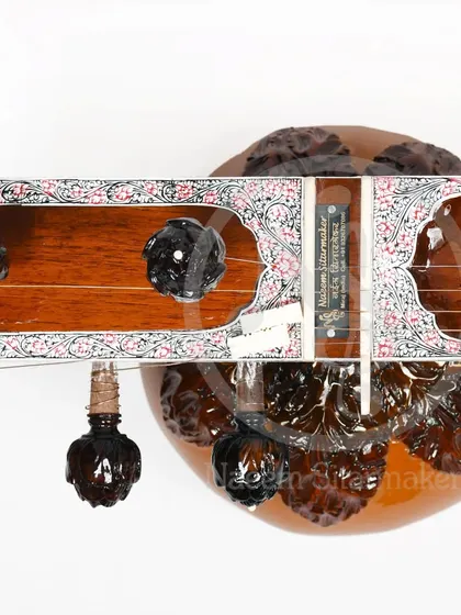 The headstock of a Pandit Ravi Shankar style sitar, featuring intricately carved pegs. These details are a signature of high-quality, handmade instruments from Miraj.