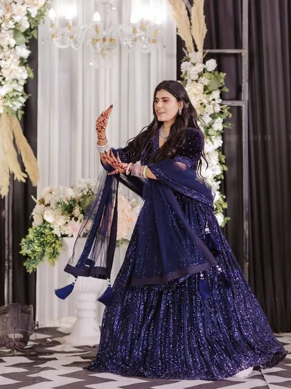 The bride commands the stage with a graceful, traditional pose during her solo performance.
