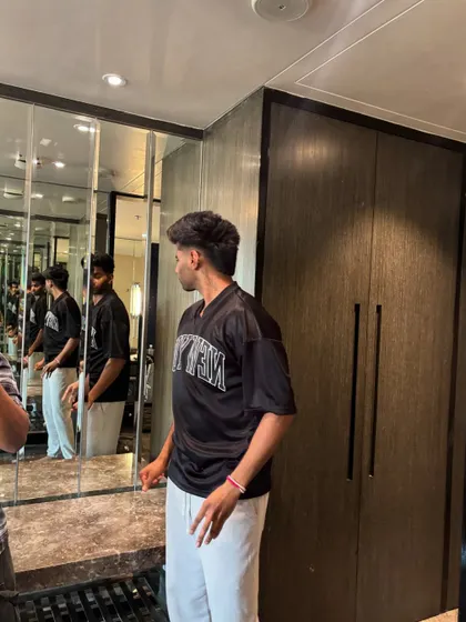 Mayank Yadav checking his new haircut in the mirror.