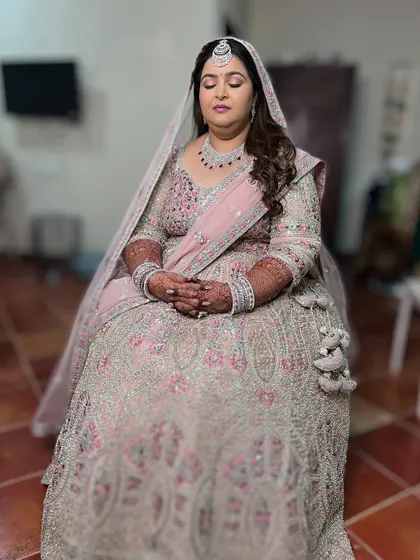 A serene, full-length shot of the bride, looking like a princess in her heavily embellished lehenga.