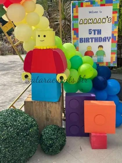 A cheerful LEGO figure and oversized blocks create an inviting entrance and a fantastic photo opportunity for guests arriving at the party.