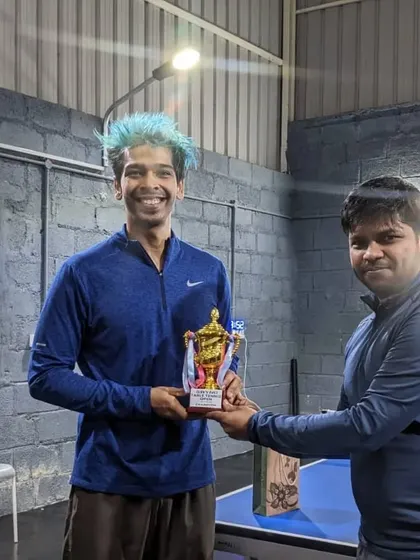 The champion of our Table Tennis Open receiving his trophy. We partner with local clubs like Taoball to enhance the tournament experience.