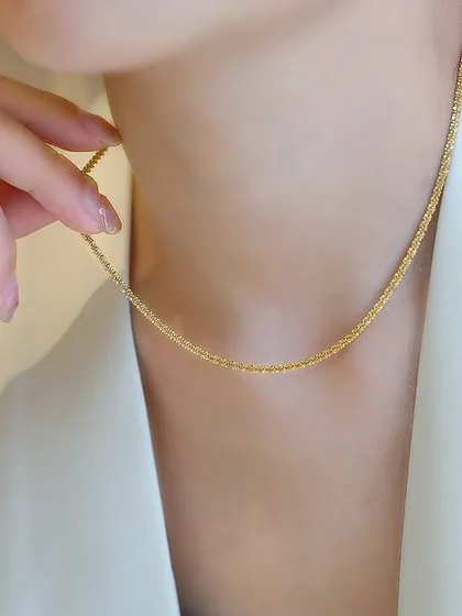A delicate, shimmering double-strand necklace worn to show how it catches the light. This piece offers a subtle sparkle for an elegant look.