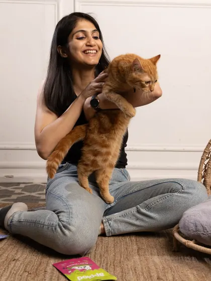 A pet parent shares a playful moment with her ginger cat, getting excited for our Meow Fest celebration.