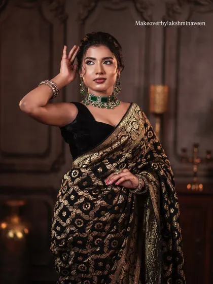 A classic pose showing the model's profile and the beautiful updo that complements the saree look.