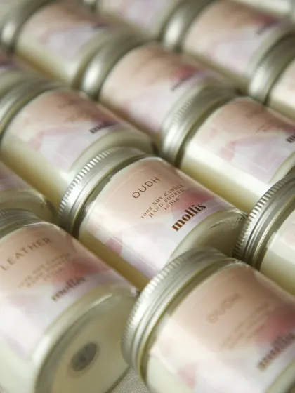 A close-up on the Oudh scented candle, part of a beautiful baby announcement gift set.
