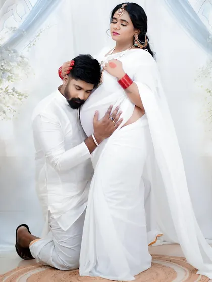A touching and intimate moment. The soft, natural makeup ensures that the focus remains on the emotional connection and the beauty of their pregnancy journey.