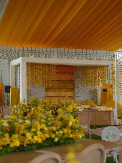 A wide shot of the Haldi setup, showing the blend of garden elements with the structured stage design.