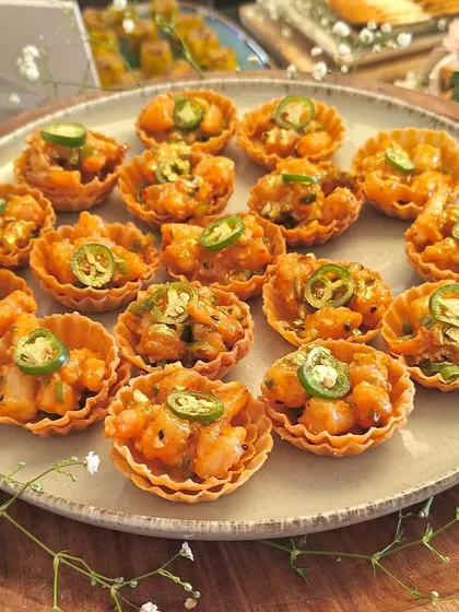 A platter of our spicy water chestnut tarts, topped with jalapeños. These bite-sized tarts offer a delightful crunch and a kick of flavor.