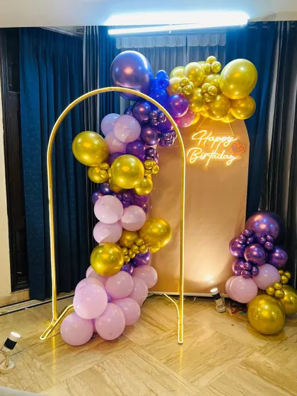 Another view of the modern purple and gold balloon decoration, showing how it fits perfectly into a corner of a room to create a festive photo spot.