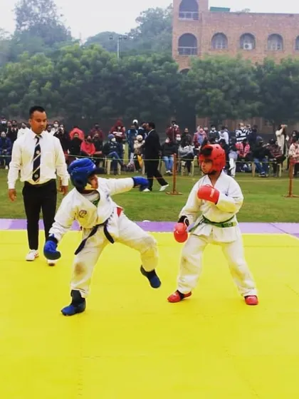 Even my youngest Tigers compete with great spirit and technique. This action shot captures two young students during a sparring match, fully equipped with safety gear.