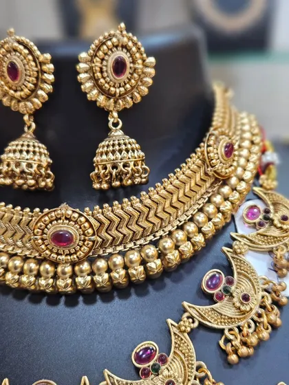 The matching jhumka earrings and the detailed choker complete this stunning traditional bridal set.