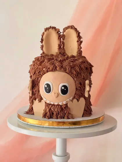 This furry monster cake is all about texture. I used a special piping technique with chocolate buttercream to create the shaggy fur, and the friendly face is made from fondant.