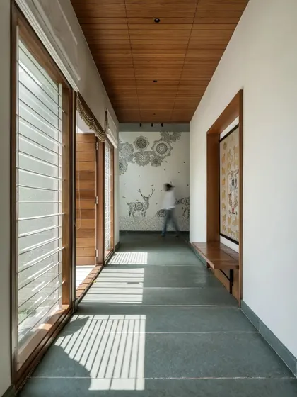 A central corridor with a Kota stone floor and a warm wooden ceiling connects the different zones of the house, with art pieces providing moments of visual delight.