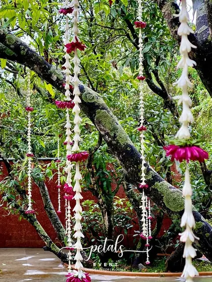Floral streamers hang from the trees, creating a whimsical and romantic atmosphere.