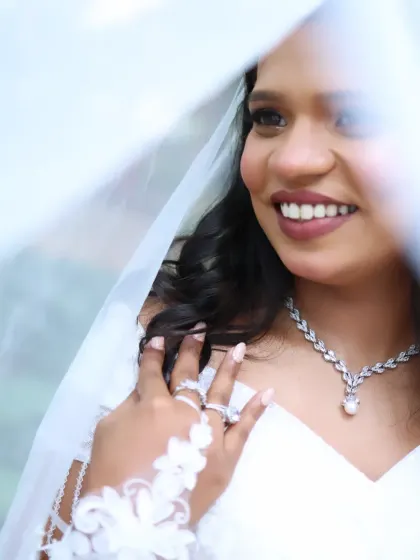 A dreamy close-up of the bride through her veil. The soft lighting enhances her glowing skin and the romantic feel of her makeup.