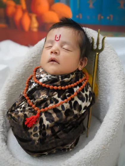 This shot captures the baby with a tilak on the forehead, adding an authentic detail to the 'Little Shiva' newborn theme.