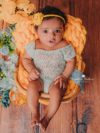 An overhead shot that captures the entire beautiful setup. The wooden floor, colorful flowers, and cozy basket create a warm and inviting scene.