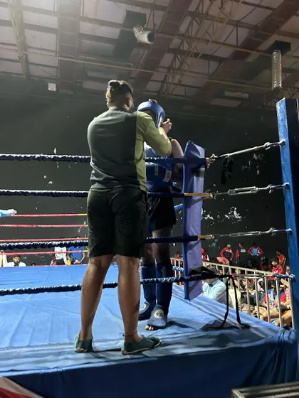 Adjusting headgear for a youth fighter during a national championship bout. Safety and strategy go hand in hand.