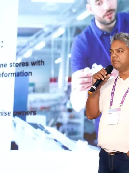 A close-up of a presenter at the UXINDIA summit, with his presentation visible in the background. This type of shot is useful for documenting the specific content and key speakers of your conference.