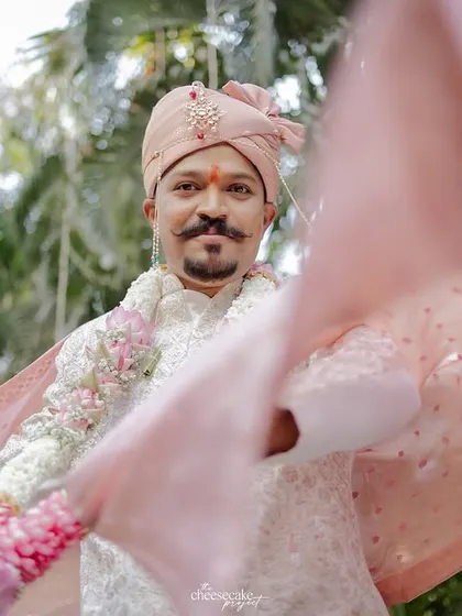 A creative shot of the groom with his dupatta flowing in the foreground.