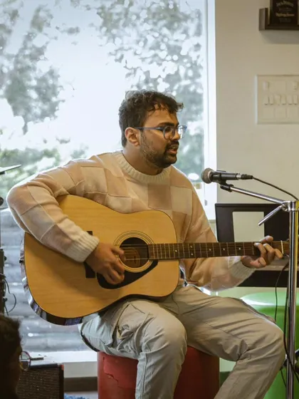 A student performing an acoustic set at a recital. These sessions are perfect for singer-songwriters to test out their material.