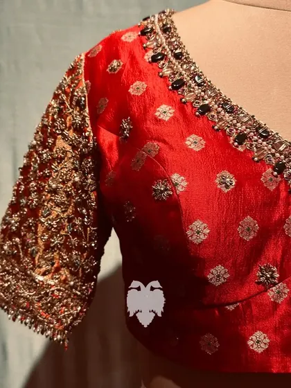 A unique red blouse combining Kanjeevaram zari on the sleeves with Banarasi silk on the body.