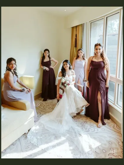 The bride and her bridesmaids sharing a moment before the ceremony. The coordinated dresses and the bride's stunning gown create a beautiful and cohesive image.