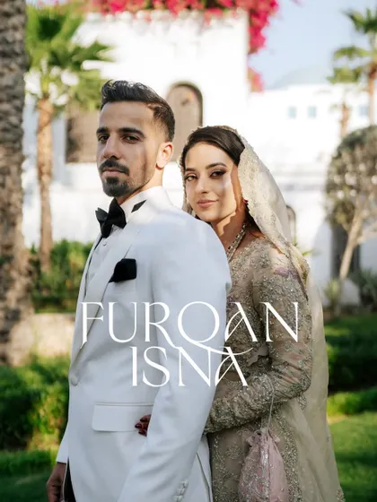 A stylish, editorial-style portrait of the couple. The groom's white tuxedo and the bride's elegant gown create a very modern look.