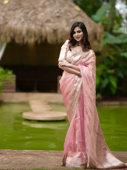 A beautiful pink tissue silk saree with a golden border, paired with a matching puff-sleeve blouse. A perfect blend of grace and luxury.