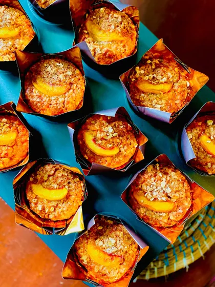 Another top-down view of the muffins, showing the lovely texture and the slice of peach on each one.