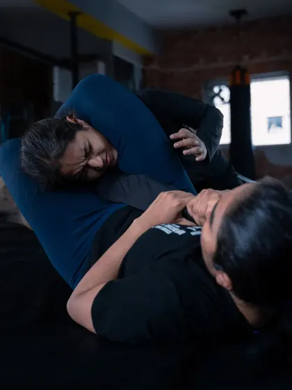 The intensity of ground training. Here, two students are drilling submission techniques, learning to use their entire body to apply and escape from holds.