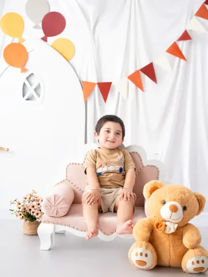 A relaxed and happy portrait of a toddler sitting with his teddy bear friend. I create a comfortable environment where kids can be themselves.