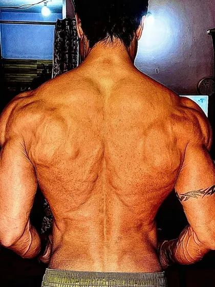 A powerful back lat spread, showing the width and strength gained from leaving an unhappy life behind.