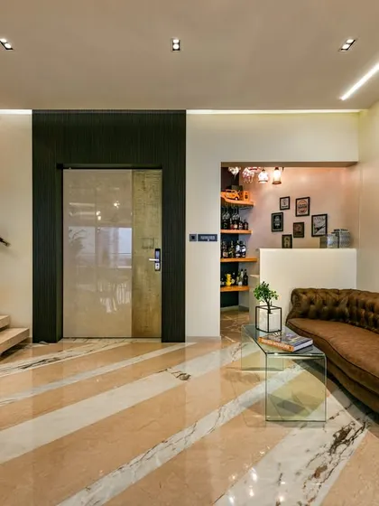 I had the unique joy of designing this Mumbai home twice. The reimagined entry lobby unfolds into an informal living space layered with textures, from a lush tropical green wall to a diagonally patterned floor that defines the area with elegance.