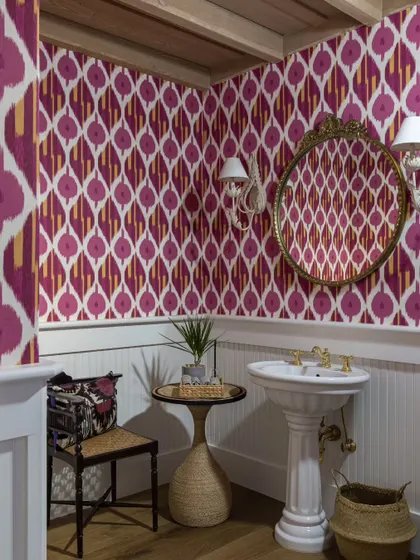 A powder room in the Saratoga home, where we used a bold, vibrant ikat wallpaper to make a statement. Paired with a classic pedestal sink and a vintage-style mirror, it’s a small space that is packed with personality.