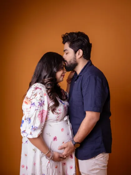 That look of love says it all. We captured this intimate moment between partners against a warm, simple studio backdrop, letting their connection be the focus.